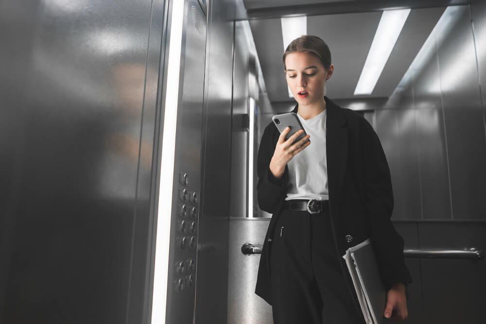 woman-in-elevator-on-cell-phone